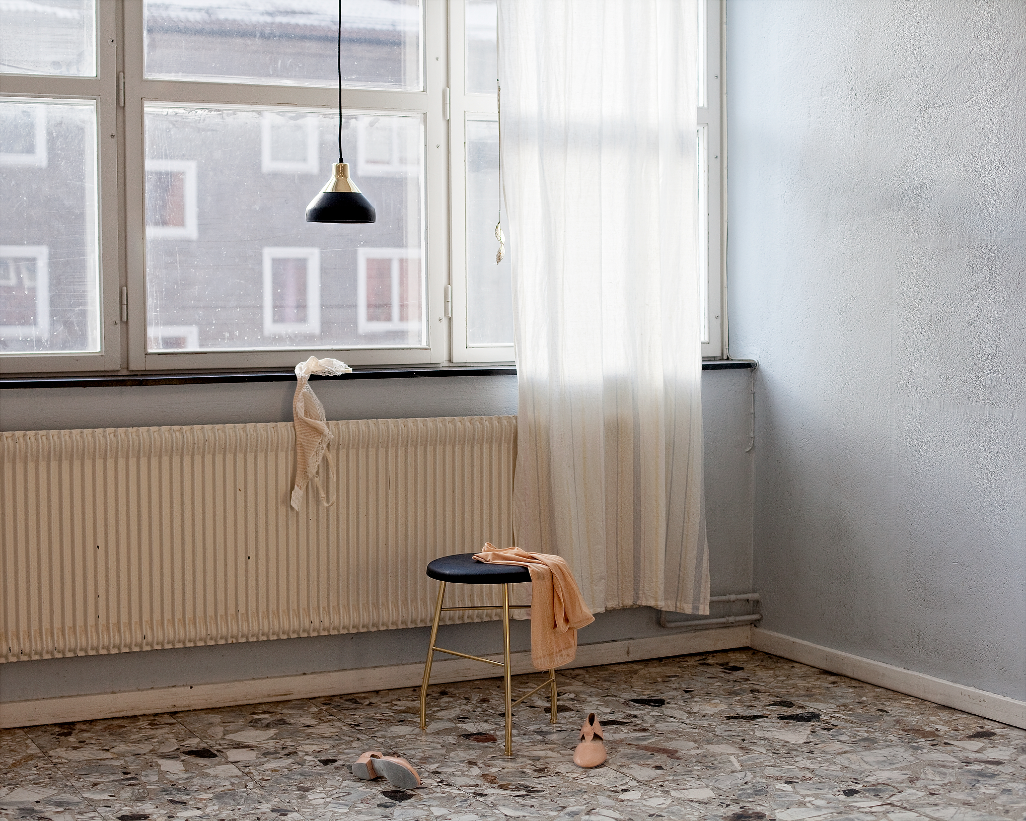 portrait photograph that shows Stephanie, a laughing young woman with wavy brown hair in front of a pink wall.